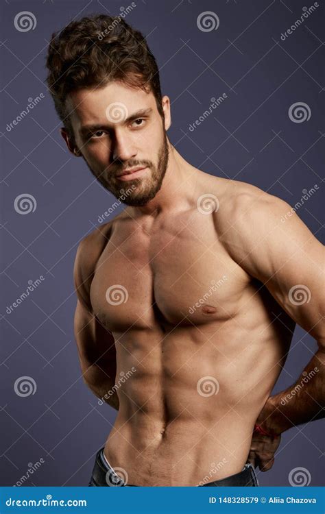 Shirtless Strong Well Built Guy Standing In The Studio With Black Wall