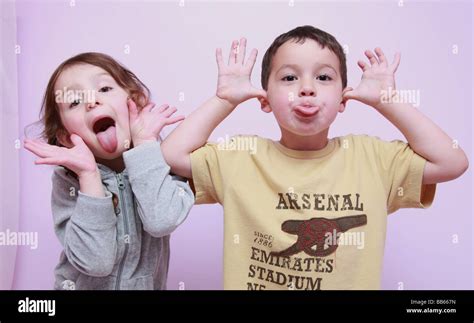 2 Cheeky Children Pulling Faces Stock Photo Alamy