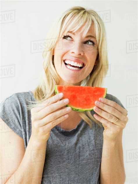 Studio Portrait Of Blonde Woman Eating Watermelon Stock Photo Dissolve