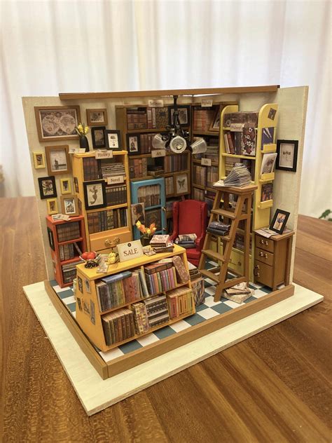 A Miniature Model Of A Library With Bookshelves Ladders And Pictures