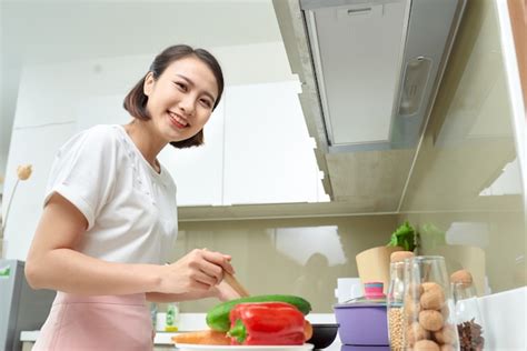premium photo happy asian woman cooking in the kitchen