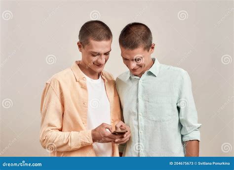 Deux Jeunes Fr Res Jumeaux Gays Dans La Tenue De D Tente L Aide De L Application Smartphone