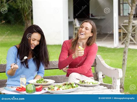 Två Kvinnliga Vänner Som Tillsammans Skrattar Och Har Lunch Fotografering för Bildbyråer Bild