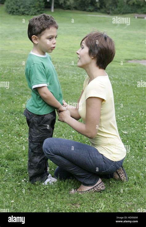 La Joven Madre Hablando Con Su Hijo El Niño En El Parque Fotografía De