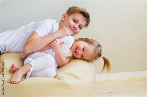 Big Brother And His Cute Little Sister Laying Togetherness Fun At Home Two Caucasian Siblings