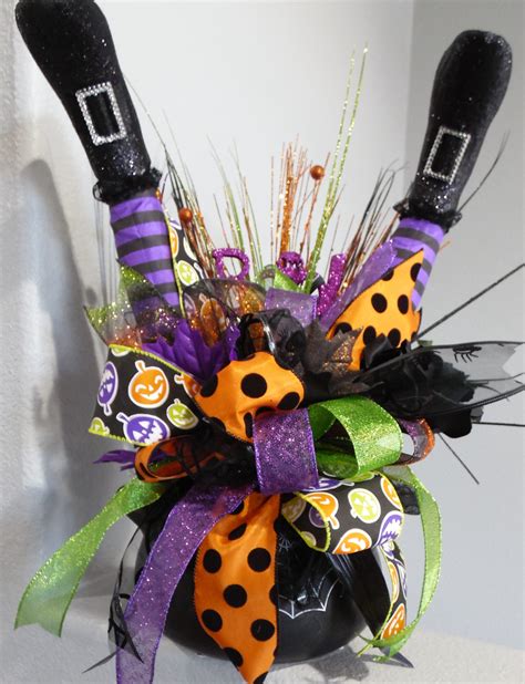 This wreath is decorated with a broom with a wooden sign that reads: Witch Cauldron Centerpiece Witch Legs Centerpiece Halloween