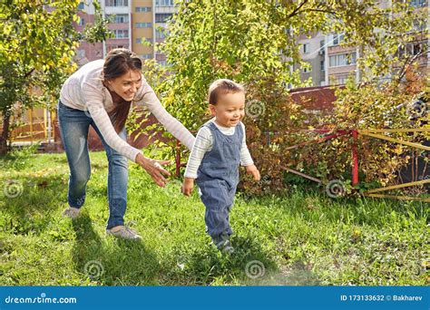 Young Mother Playing With Her Baby Mom And Son Walking In A Park