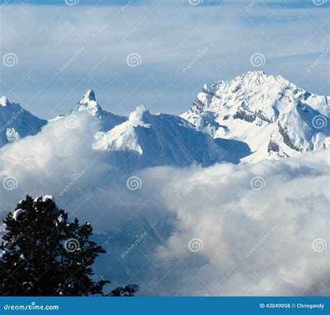 Low Cloud Winter Alpine Mountain Scene Under A Blue Sky Stock Photo