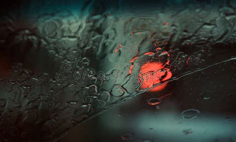 Blurry Rain Waters With Red Glowing Lights Reflection On Glass Stock