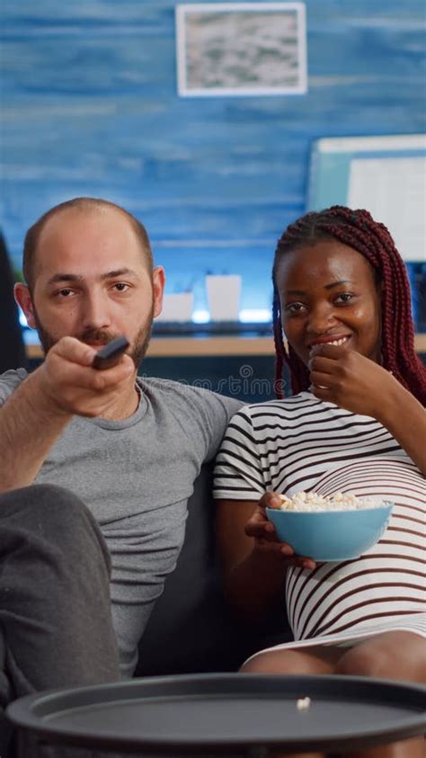Pov Of Interracial Couple With Pregnancy Watching Television Stock