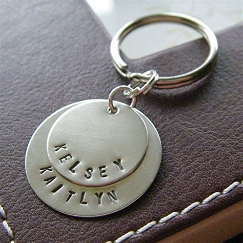 A Close Up Of A Key Chain On A Leather Case With A Name Tag Attached To It