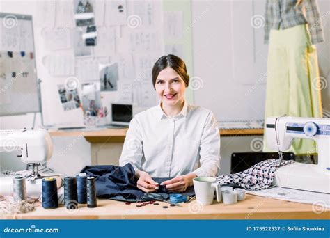 Smiling Female Fashion Designer Sitting At Office Desk Dressmaker Tailor Works And Seamstress