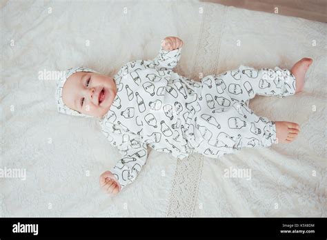 Newborn Baby Dressed In A Suit On A Soft Bed In The Studio Stock Photo