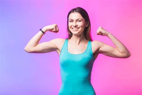 Portrait Of Athletic Young Woman Showing Biceps Muscles Isolated