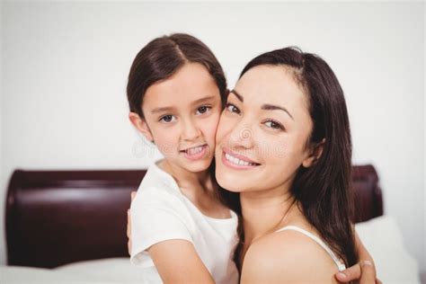 Portrait Of Mother Smiling While Hugging Daughter On Bed Stock Image Image Of Happiness