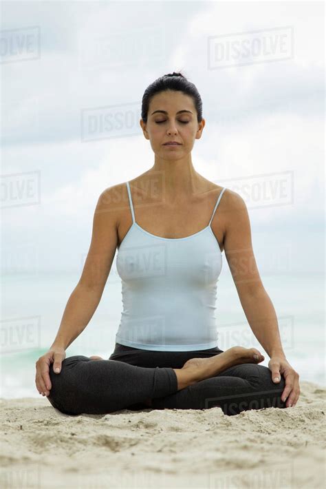Mature Woman Meditating On Beach Portrait Stock Photo Dissolve