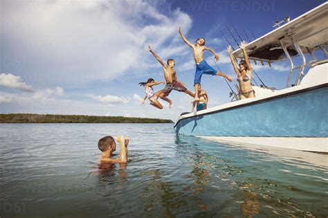 Children Jumping From Boat At Sea Against Sky Cavf19716 Cavan