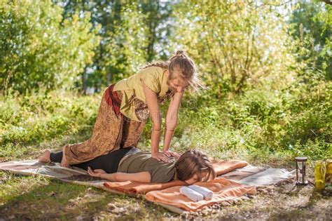 Massage Professional Demonstrates Refreshing Massaging Methods On The Grass Of The Forest Stock