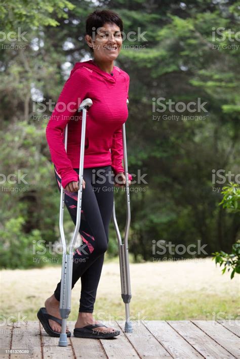 Woman Walking With Crutches Outdoors Stock Photo Download Image Now