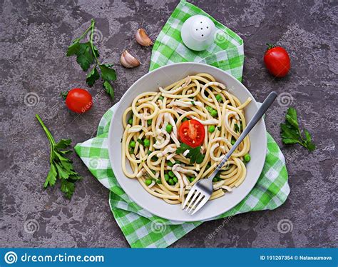 Bucatini Pasta With Squid And Green Peas In A Gray Bowl On A Dark Gray