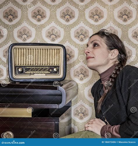 Caucasian Woman Listens To Music From An Old Radio Stock Photo Image