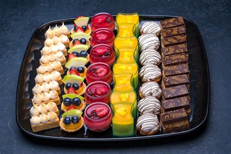 A Tray Filled With Lots Of Different Types Of Desserts On Top Of Each Other