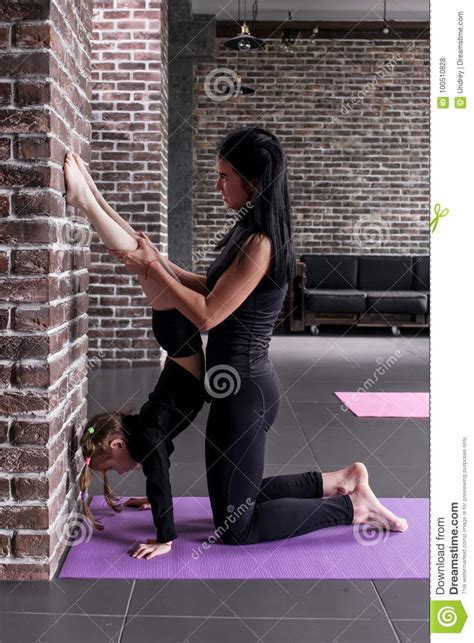 Young Female Gymnastics Teacher Assisting The Child Girl Doing