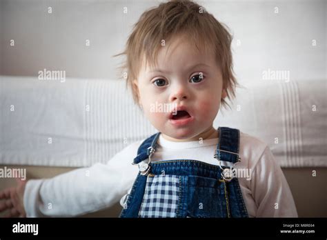 Portrait Of Cute Baby Boy With Down Syndrome In Home Living Room Stock