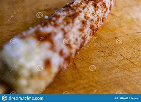 Mexican Corn With Chili Powder And Grated Cheese On A Wooden Surface
