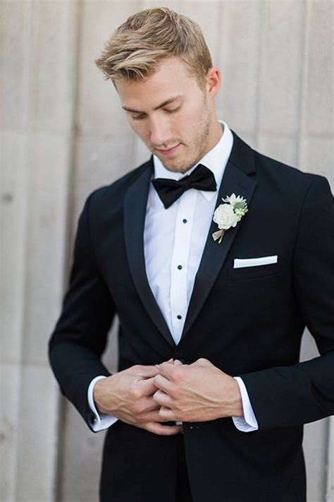 boutonniere style black notch lapel tuxedo with a black bow tie and a simple white floral bo