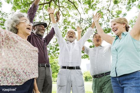 Group Of Happy Retired Senior Friends In The Park Cheering Premium