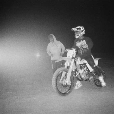 A Man Riding On The Back Of A Dirt Bike In The Middle Of The Night