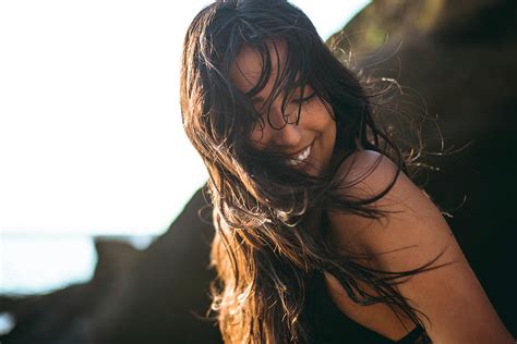 Young Latina Woman Laughing By The Ocean At Golden Hour In Summertime Photograph By Cavan Images