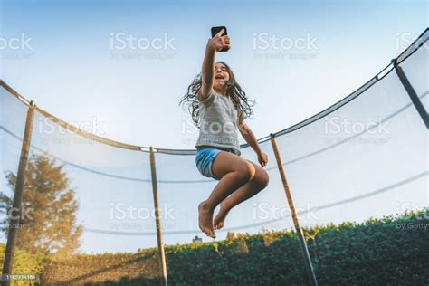 Select from premium trampoline jumping images of the highest quality. Little Girl Jumping High On Trampoline With Mobile Stock Photo - Download Image Now - iStock