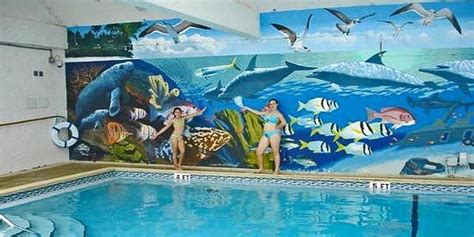 An Indoor Swimming Pool With Murals On The Wall