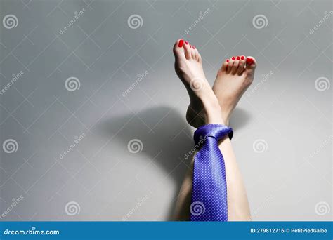 Close Up Of A Beautiful Woman S Feet With Red Nails Tied With Blue