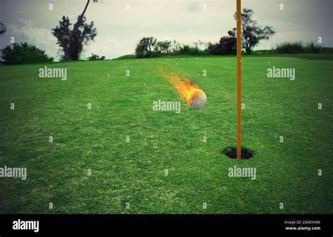 Fiery Golf Ball Near The Hole In A Green Grass Field Stock Photo Alamy