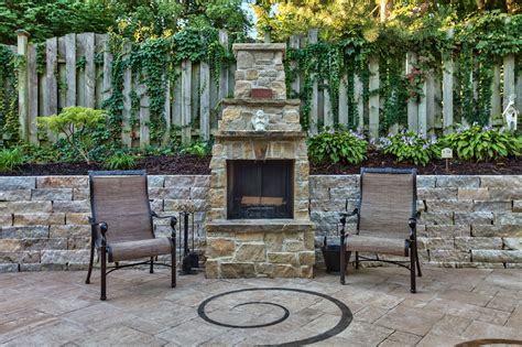 An Elegant Stone Fireplace Was Built Into A Retaining Wall To Make The