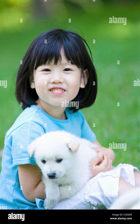 Girl Hugging Baby Dog Stock Photo Alamy