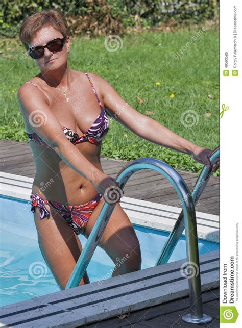 Caucasian Woman Standing On Stairs Of Swimming Outdoor