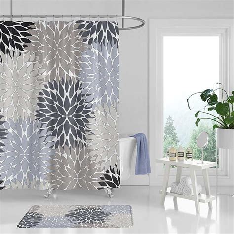 A Bathroom With A Shower Curtain Rug And Potted Plant On The Floor In
