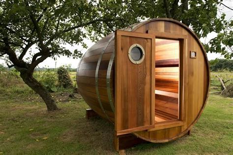 A Barrel Shaped Sauna Sits In The Grass
