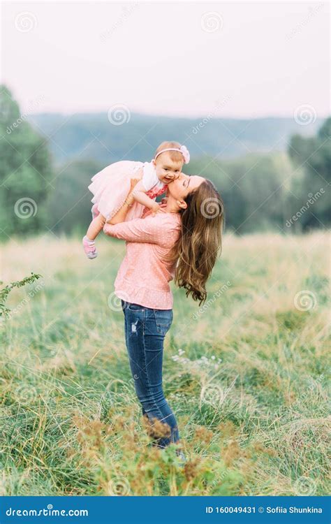 moder och dotter leker tillsammans i en park glad trevlig familj mor och barn kysser skrattar