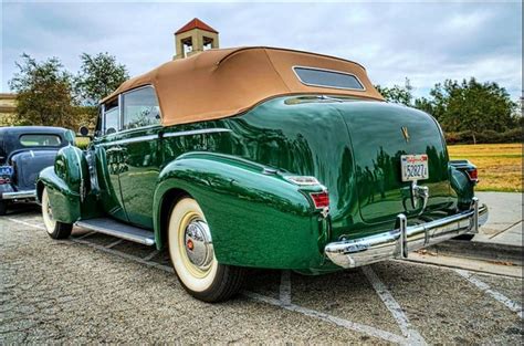 An Old Green Car Parked In A Parking Lot