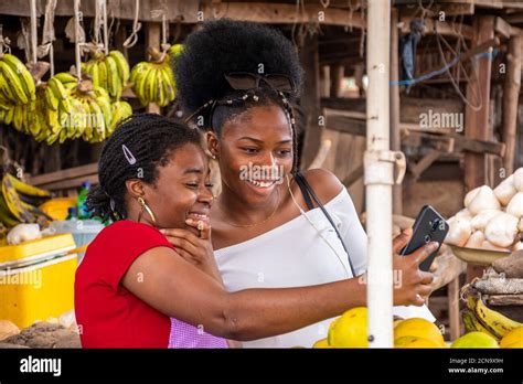 Women In A Local African Market Viewing Content On A Phone Together