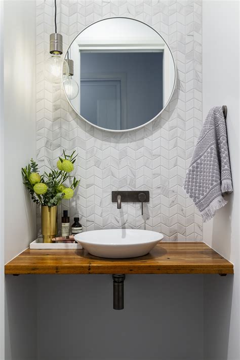 A Modern Powder Room With Marble Look Chevron Tiles And Concrete Look