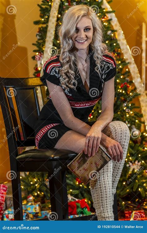 A Lovely Young Blonde Model Enjoys The Holiday Season At Home With A Christmas Tree And Presents