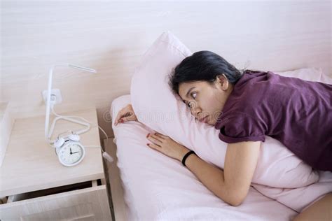 asian woman lying on the bed with alarm clock stock image image of female malaysian 181798661