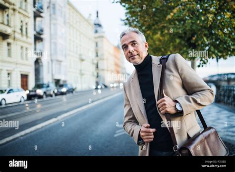 Mature Businessman Standing On The Street In City Waiting For A Taxi