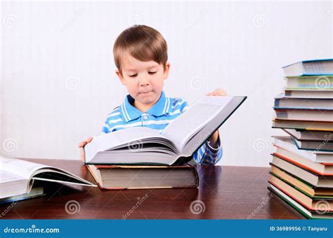 Little Boy Opens A Large Book And Looking Into It Stock Photo Image